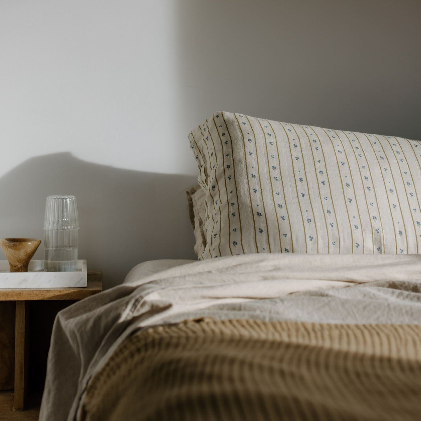 Bedroom with a bed and lamp casting shadows on the wall