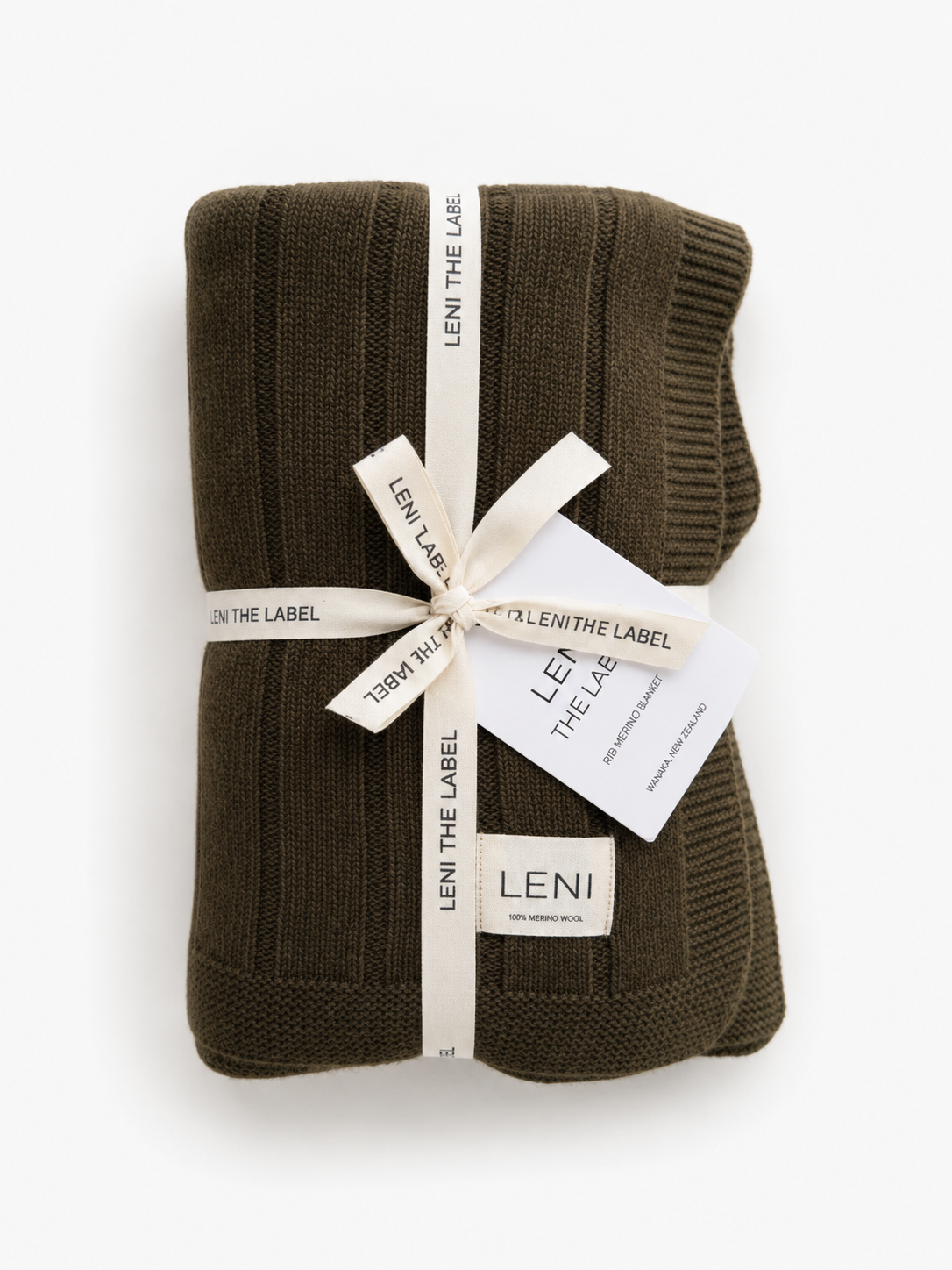 Olive ribbed knit blanket with white ribbon and 'Leni The Label' tag on a white background